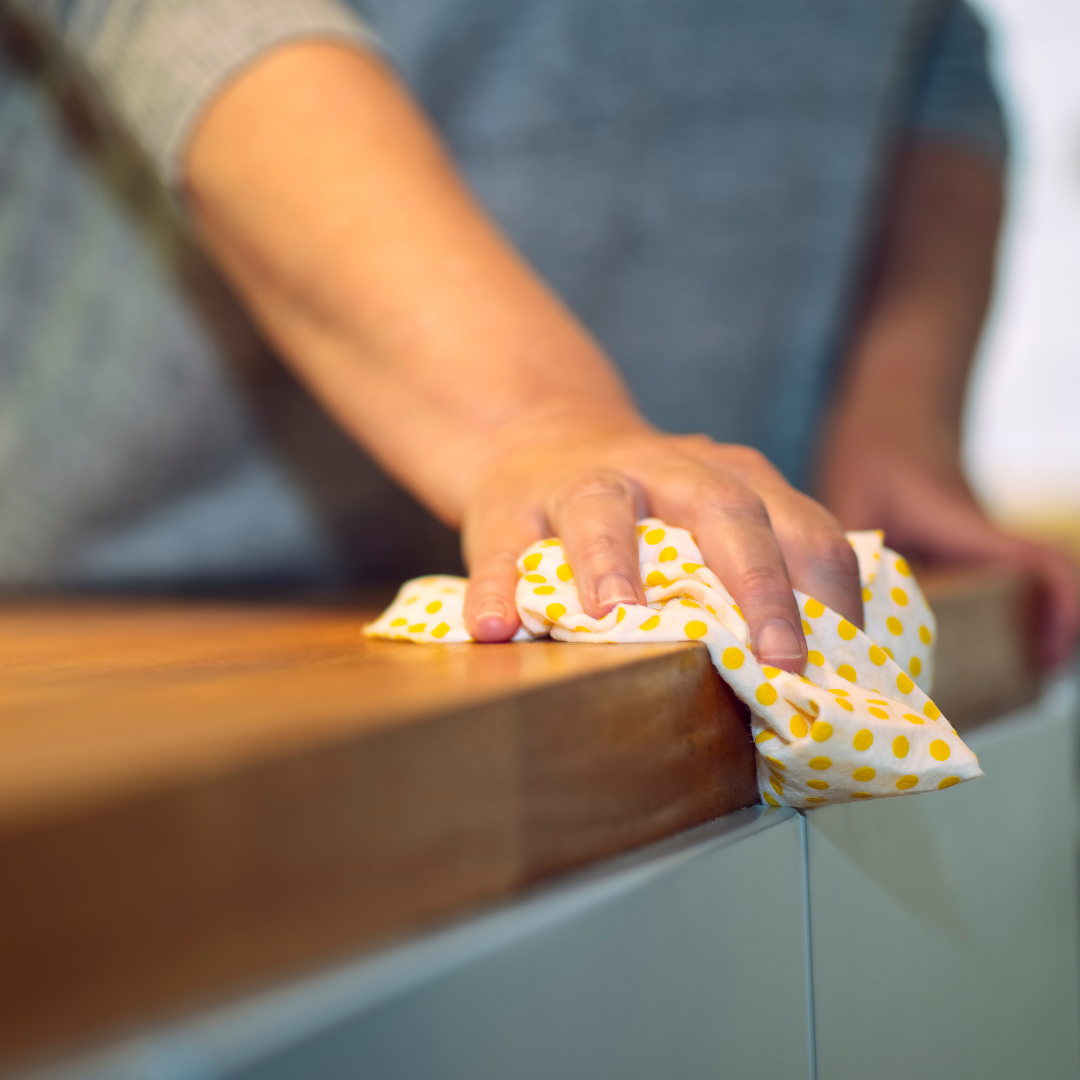 A woman cleaning with a cloth with yellow polka dots