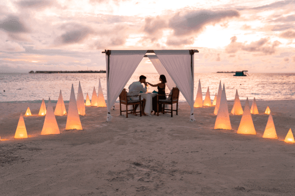 A couple having a private beach dinner at Grand Park Kodhipparu, MAldives