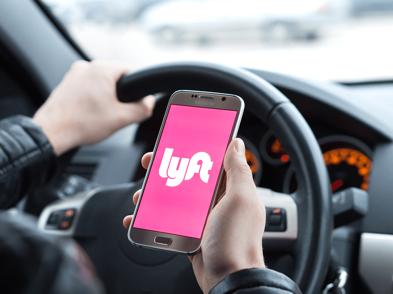 Man opening Lyft package in a vehicle, The Anaheim Hotel