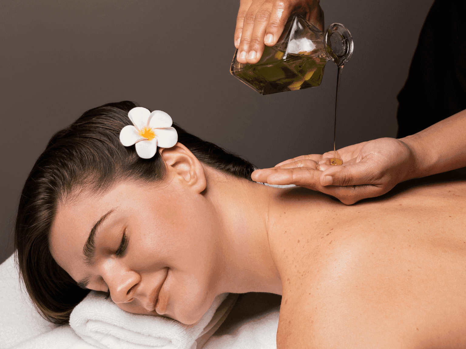 Relaxing back massage with aromatic herbal oil therapy, enhancing wellness in Dreamworks Spa at DAMAC Maison Distinction