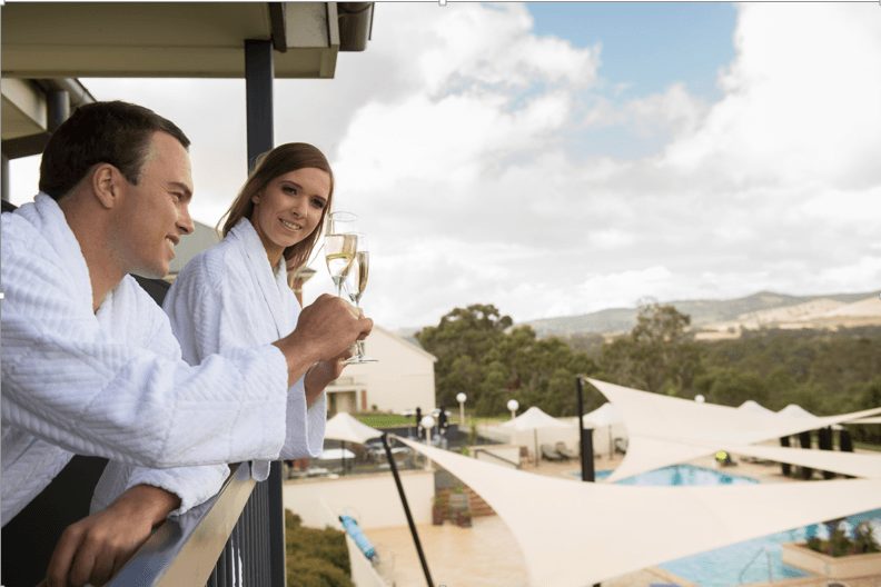 A couple toasting wine at the balcony of Novotel Barossa Valley