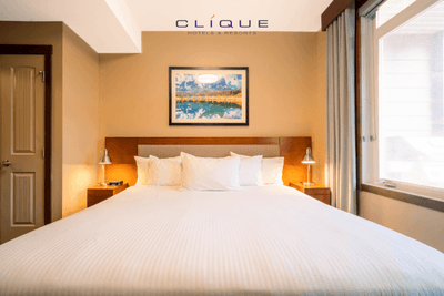 Bedroom at Falcon Crest Lodge features a comfortable king-size bed, bedside lamps, and a large window with natural light