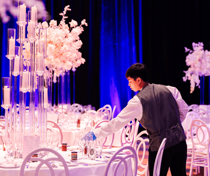 Waiter arranging glasses on a banquet in The Grand Ballroom at The Fullerton Hotel Sydney