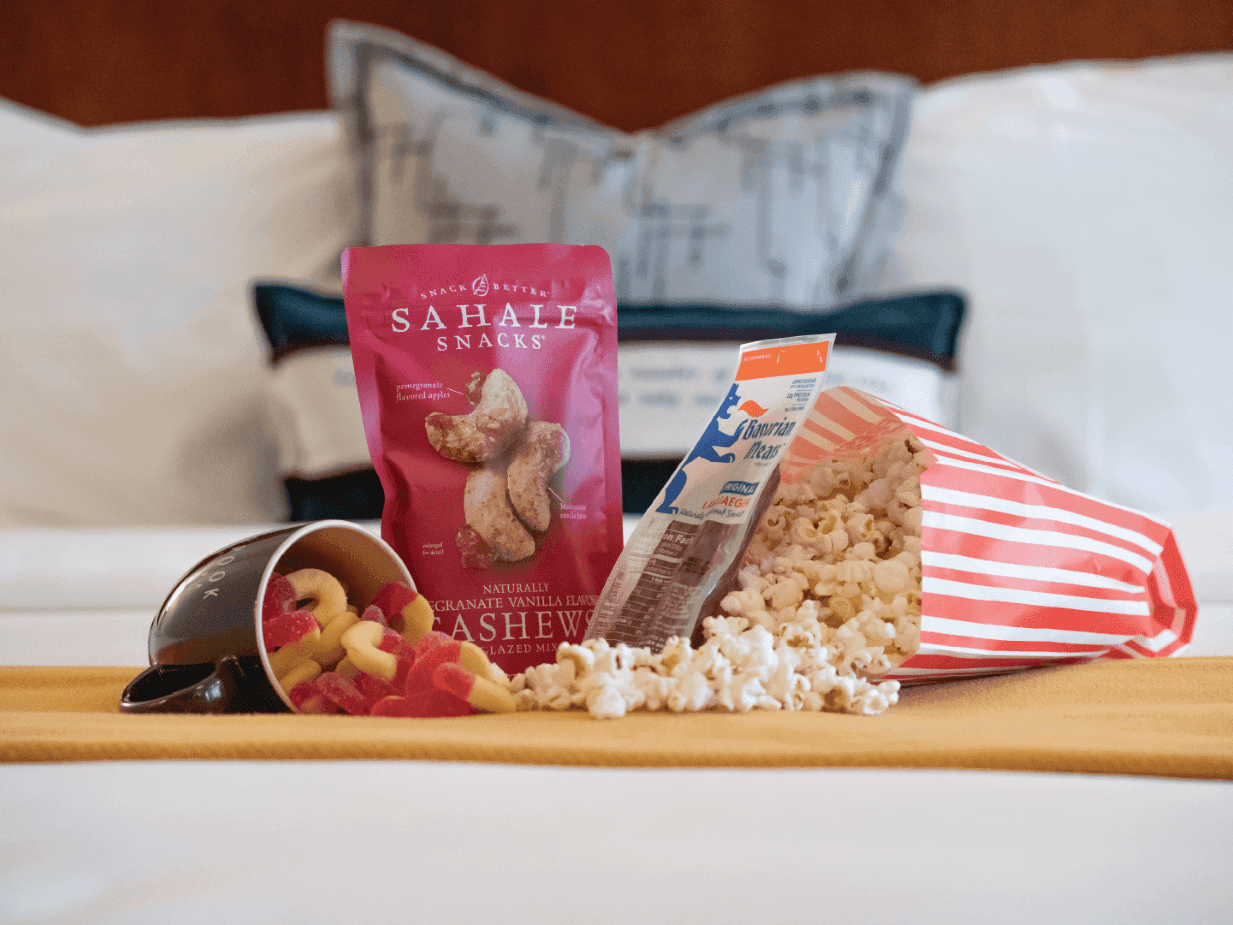 Cashews and popcorn served on a bed ready for a Movie Night at Alderbrook Resort & Spa