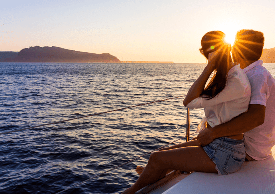 Couple embracing on a boat at sunset, overlooking the sea near Portland Harbor Hotel