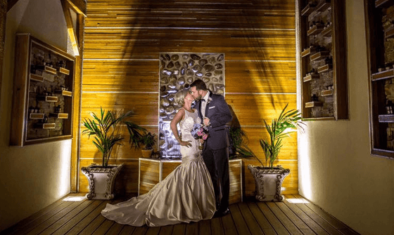 Newly-weds embracing & posing for a photo at The Wilshire Grand Hotel