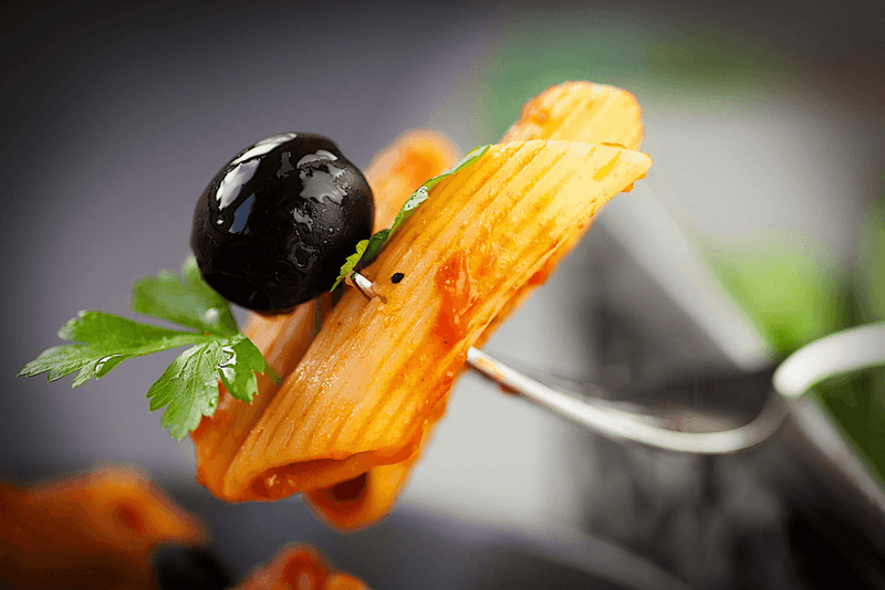 A fork with pasta and an olive