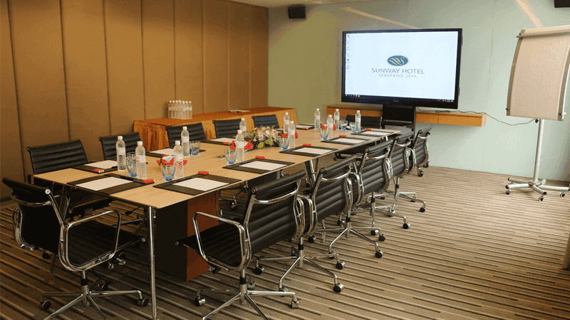 Boardroom meeting room arranged with a TV and chairs at Sunway Hotel Seberang Jaya