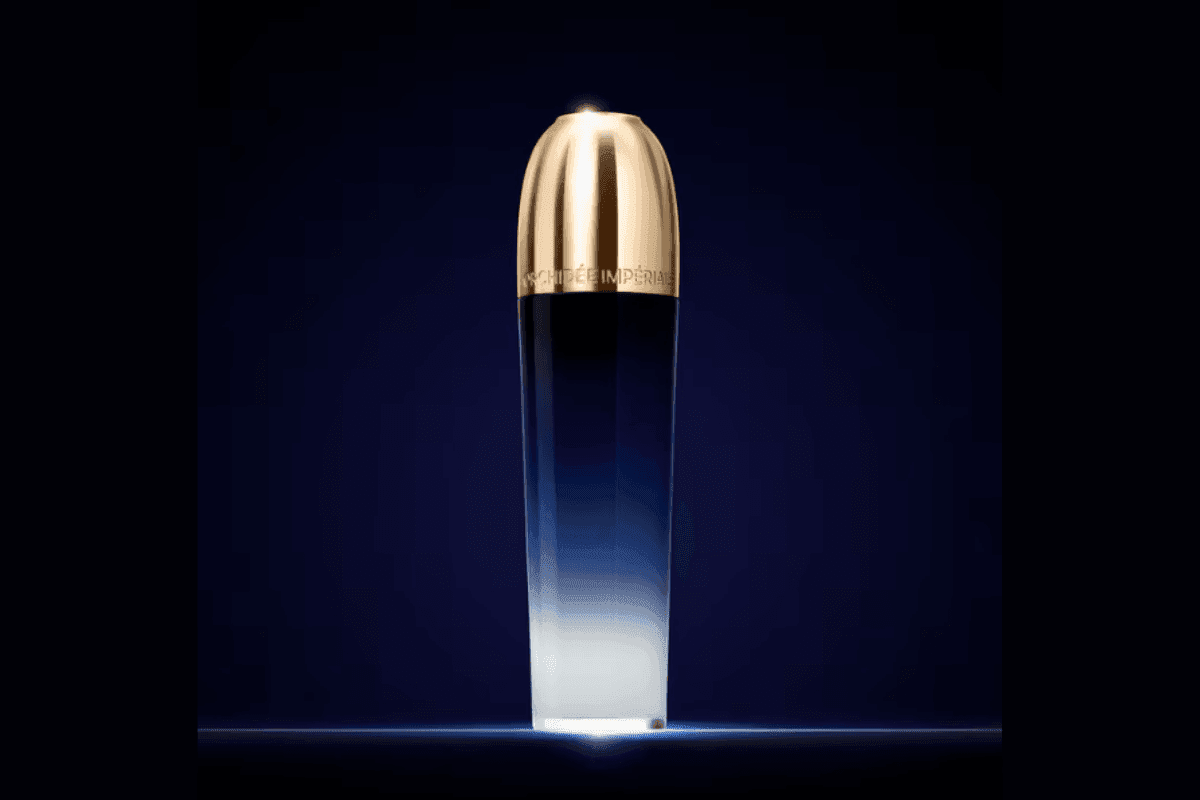 Orchidée Impériale skincare bottle with gold cap under soft light against a deep blue background at Hotel X Toronto