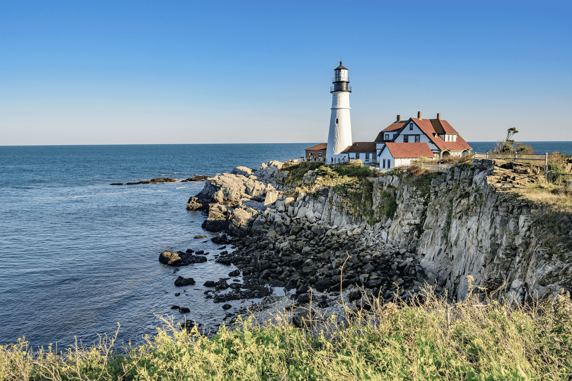 A lighthouse on a cliff overlooking the ocean.