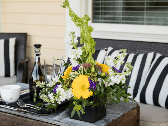 Table setting with a vibrant floral centerpiece, wine, and dinnerware at the inn at Willow grove