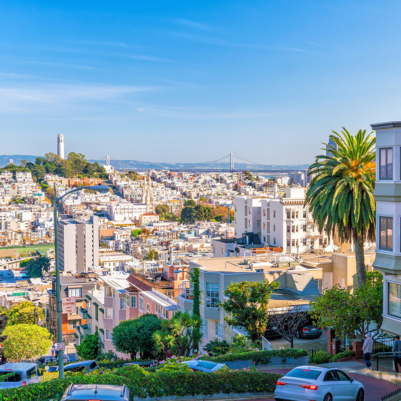 A view of San Francisco featuring Coit Tower, the Bay Bridge, and colorful buildings near Warwick Hotels and Resorts
