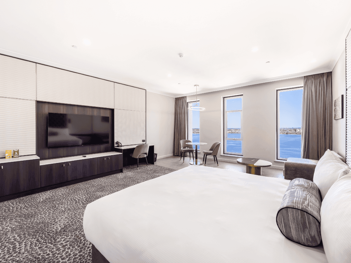 Club King River View featuring a king bed, a large TV, seating area, and panoramic windows at Duxton Hotel Perth