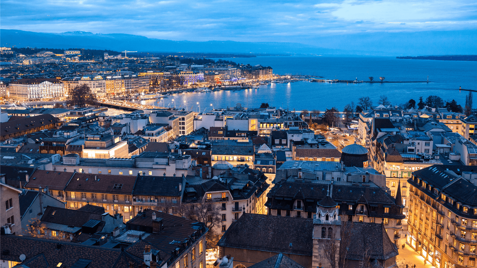 Twilight cityscape with illuminated buildings and waterfront view showcasing urban charm and serene ambiance.