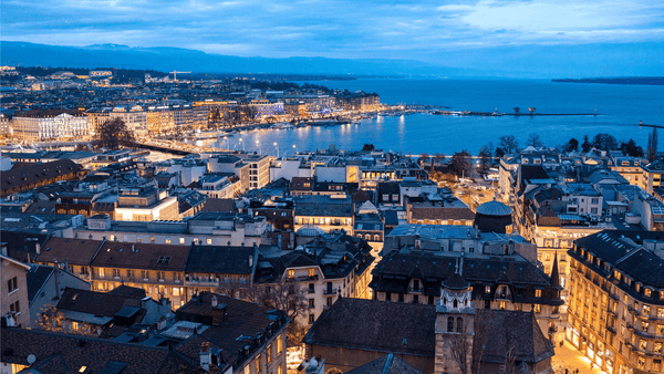 Twilight cityscape with illuminated buildings and waterfront view showcasing urban charm and serene ambiance.