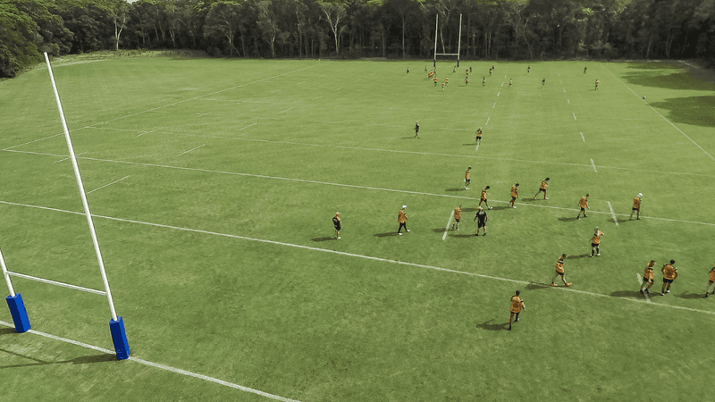 Aerial view of a rugby practice with players on an NRL Field surrounded by trees at Novotel Sunshine Coast Resort