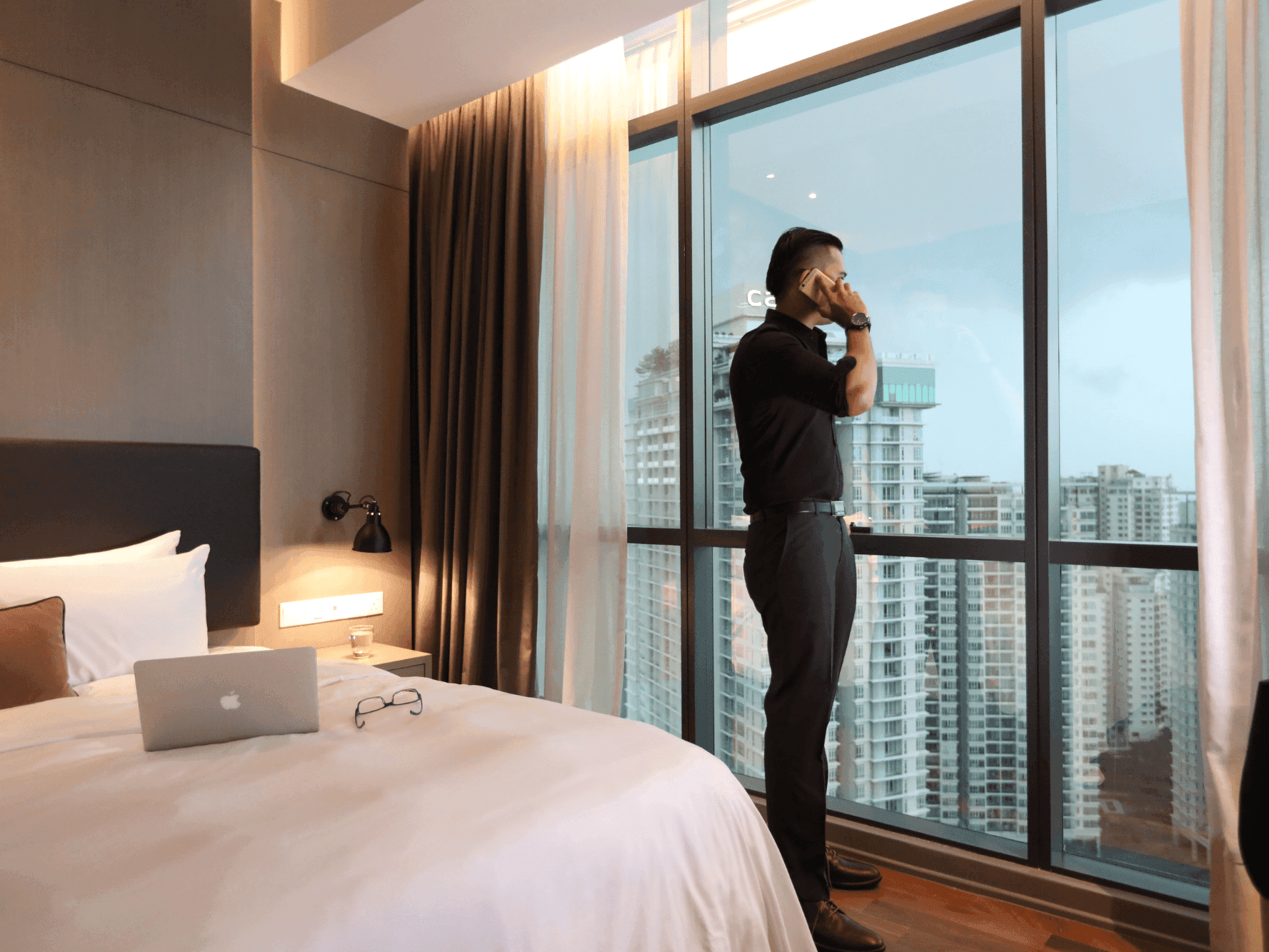 Man using a laptop on bed in a room at VE Hotel & Residence