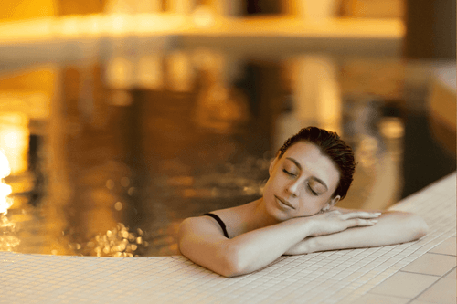 Close-up of a lady relaxing in the indoor pool at Warwick Le Crystal