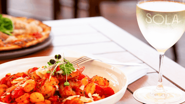 Pasta with a glass of white wine, served in Sola Bar & Restaurant at Novotel Sunshine Coast Resort