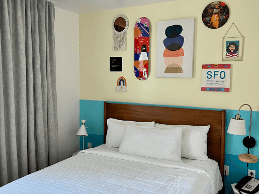 Bed and nightstands with wall art in Petite Queen Room at Beck's Motor Lodge San Francisco