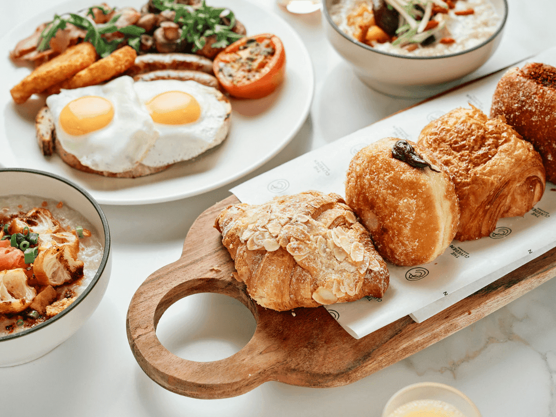 Breakfast spread with fried eggs, pastries, and savory bowls at Pullman East Melbourne
