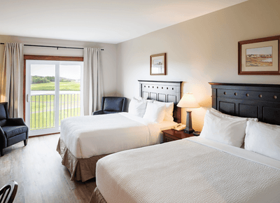 Deluxe Standard with two beds, dark wooden headboards, and golf course views at Rodd Crowbush Golf & Beach Resort