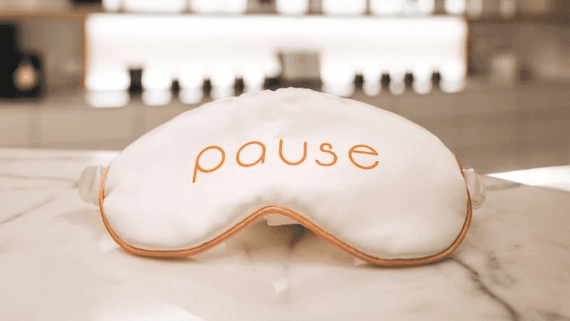 Close-up of a soft eye mask with an orange pause sign resting on a marble surface at Paramount Hotel Dubai