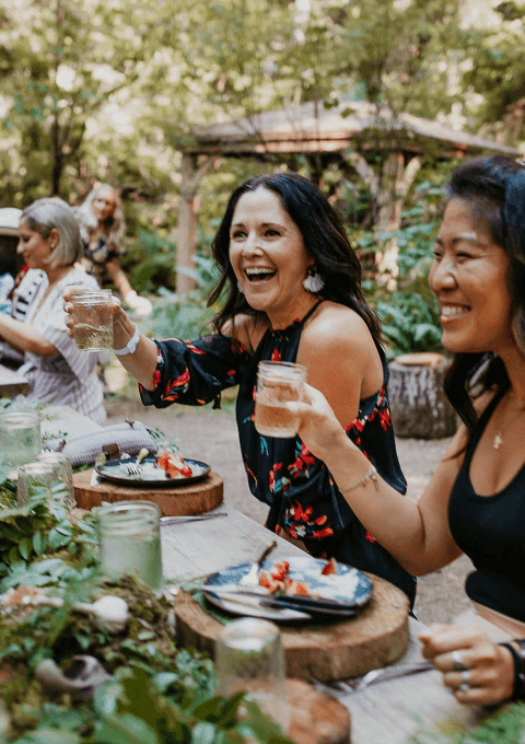 People laughing and enjoying wine outdoors at Alderbrook Resort & Spa