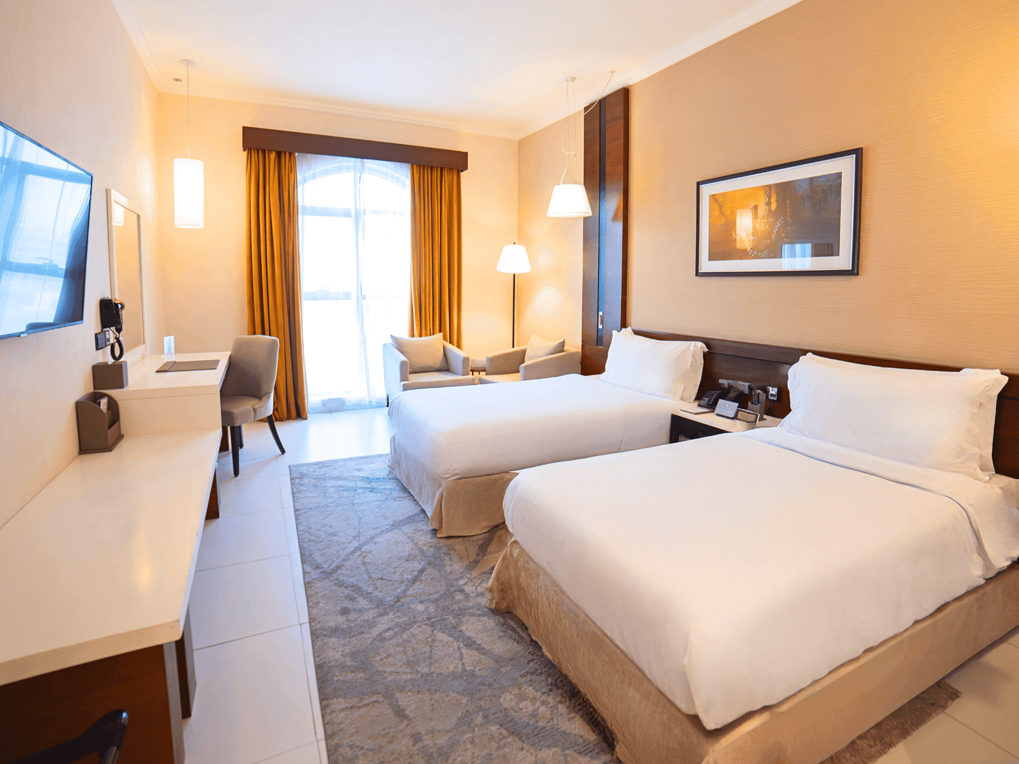 Deluxe Twin Room with two beds, desk, and balcony view at Asma Hotel in Dubai.