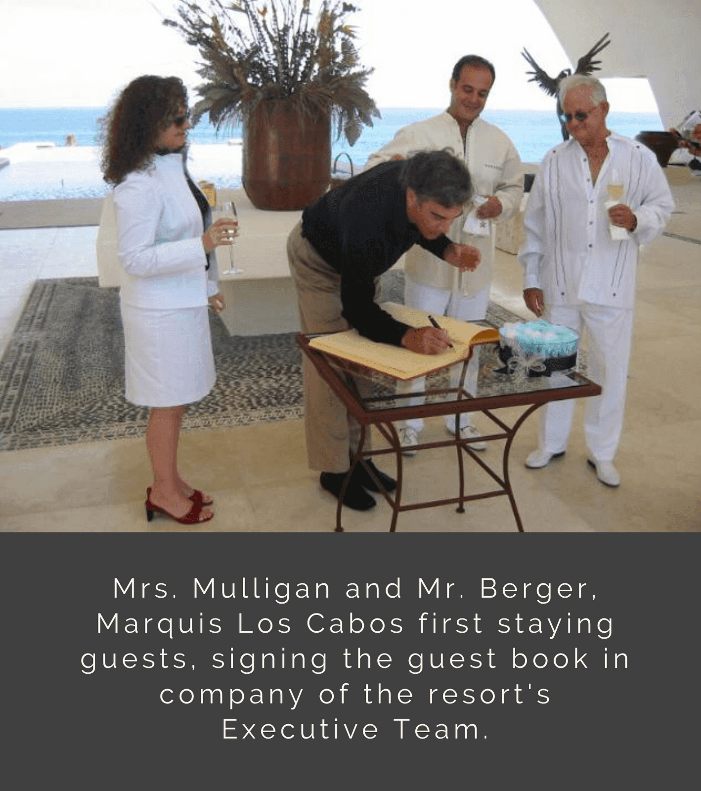 Mrs. Mulligan and Mr. Berger, the first guests at Marquis Los Cabos, signing the guest book with the resort's Executive Team