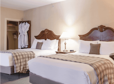 Comfortable Family Room at The Exeter Inn with two large beds and an open closet showing two white robes