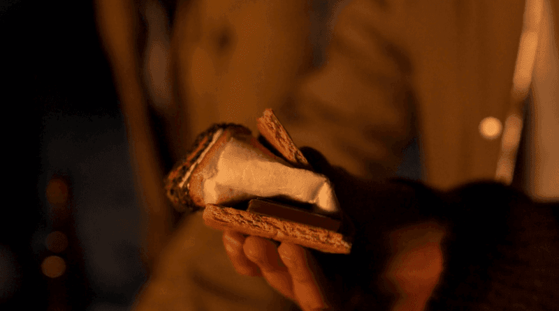 Hand holding a s\'more with toasted marshmallow & chocolate sandwiched between graham crackers at El Conquistador Resort