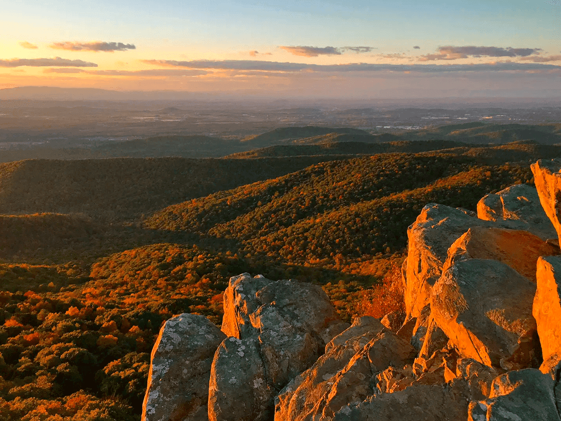 Sunset view from mountain summit on rocky foreground and hilly landscape near Inn at Willow Grove