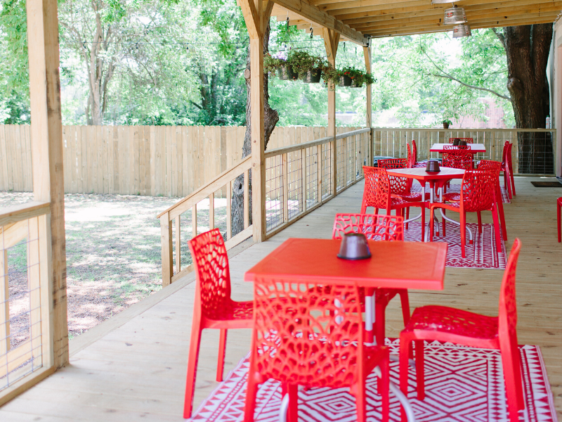chairs and tables on a wooden porch area