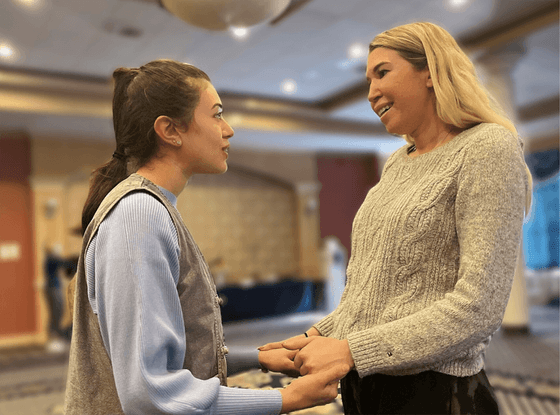 2 women holding hands and conversing at Honor’s Haven Retreat