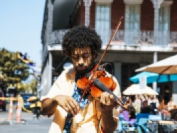 A man playing a violin in the streets near the hotel