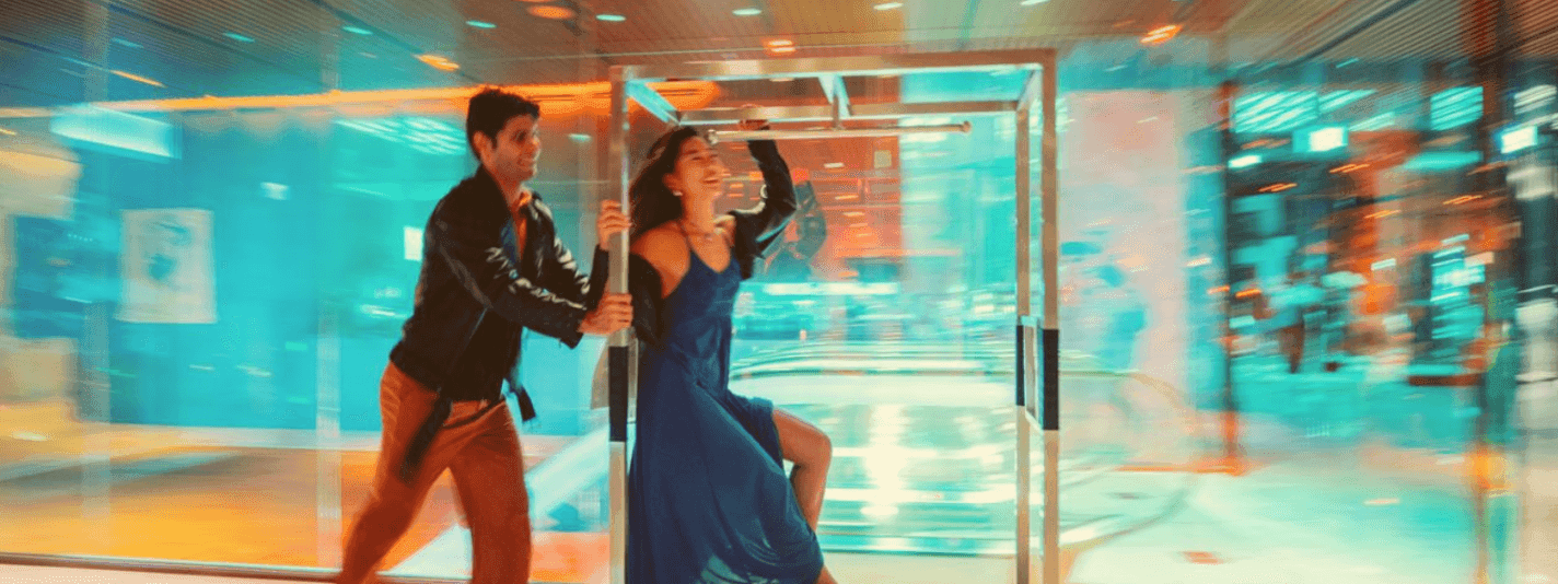 Couple dancing near glass doors with city lights in the background in the All Accor + Explorer offer.