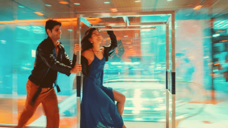 Couple dancing near glass doors with city lights in the background in the All Accor + Explorer offer.