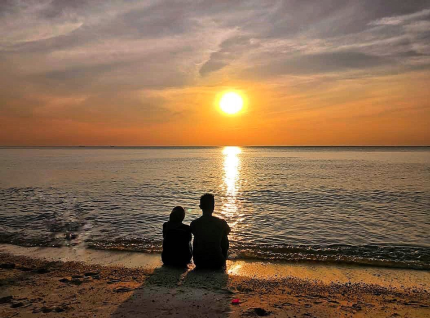 Couple enjoy sunset view at Blue Lagoon Beach Port Dickson