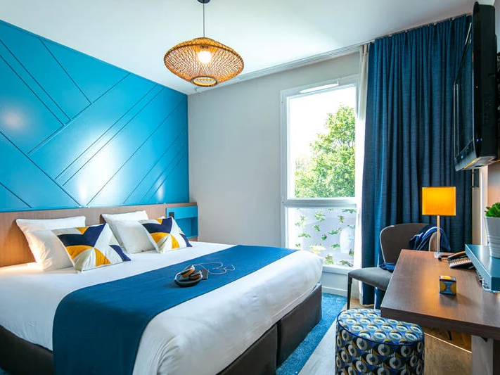 Interior of a bedroom with a balcony at Originals Hotels