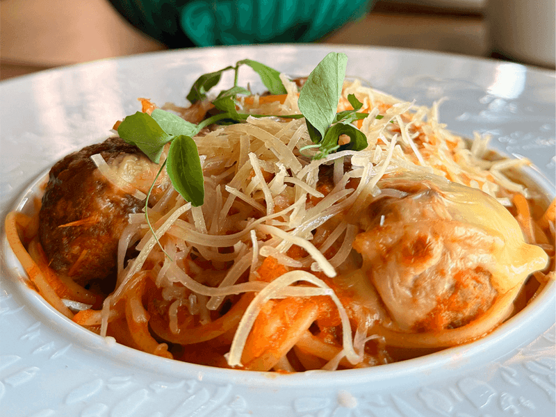 Close-up of enchiladas with melted cheese and a drizzle of crema, served at Los Canarios, Fiesta Americana Travelty