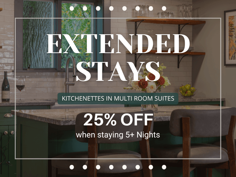 color photo of kitchenette with green cabinets, marble countertops & comfy island chairs. photo displays promo details. 