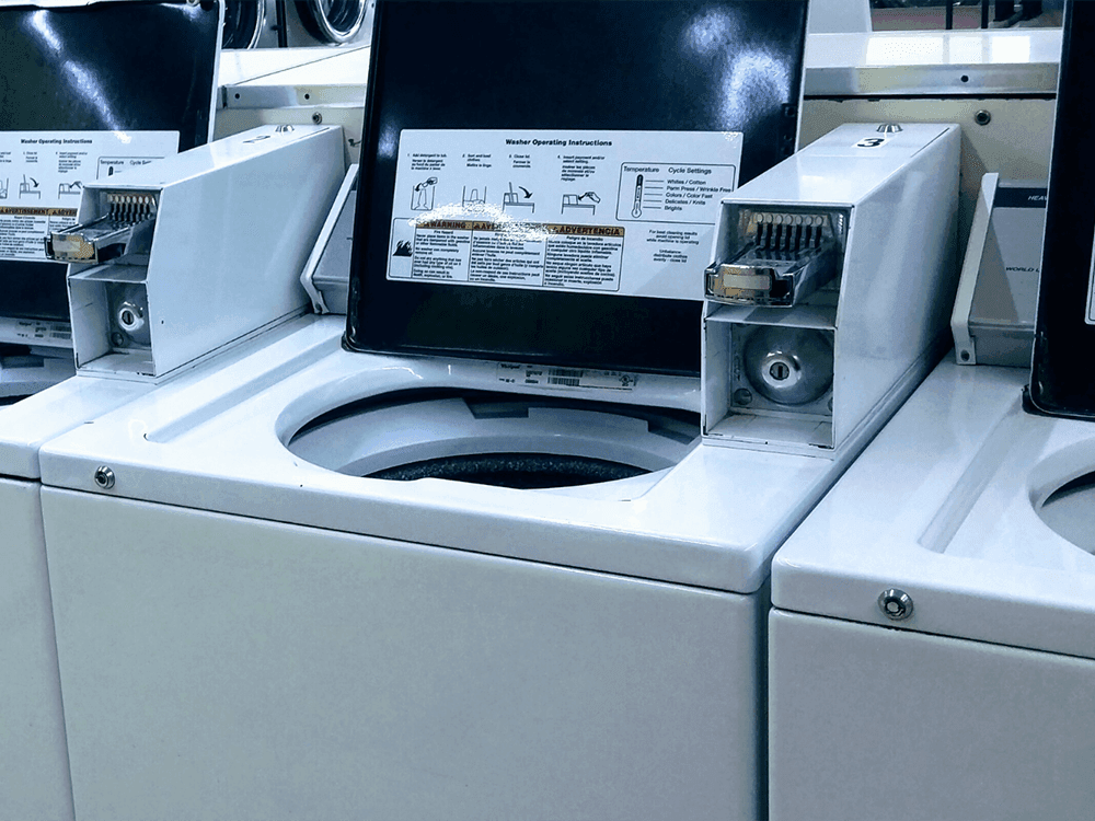 A row of open top washing machines in the Guest Laundry at Juniper Hill Inn