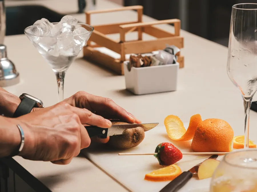 Personne coupant un fruit sur une planche à Masseria Stali.