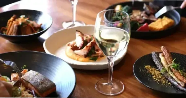 A table of food and wine at  Hotel Grand Chancellor Hobart’s Tasman Restaurant.