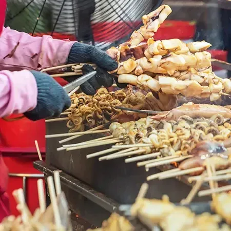 Grilled seafood skewers being prepared at street food stall - Lexis Suites Penang