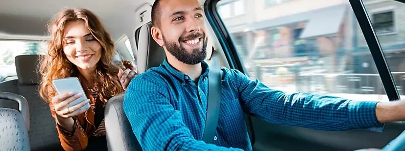 Man driving a car with a female passenger using a phone at Novotel Sydney Olympic Park