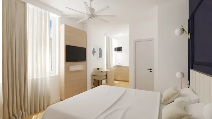 Chambre élégante avec lit, ventilateur, télévision et kitchenette chez Les Sources Callou.