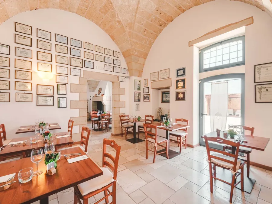Tables et chaises de restaurant décorées avec des verres et des menus à Masseria Stali.