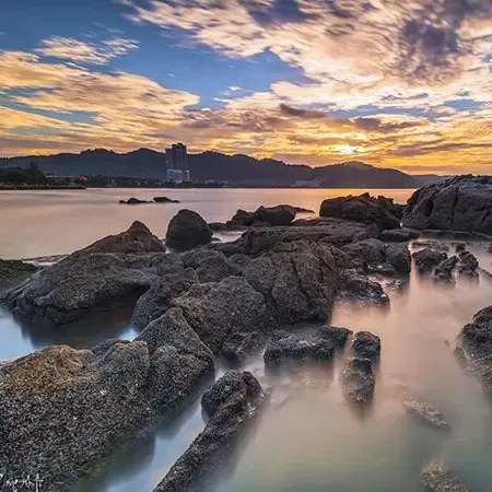 Scenic sunset view over rocky shoreline at Teluk Kumbar Penang